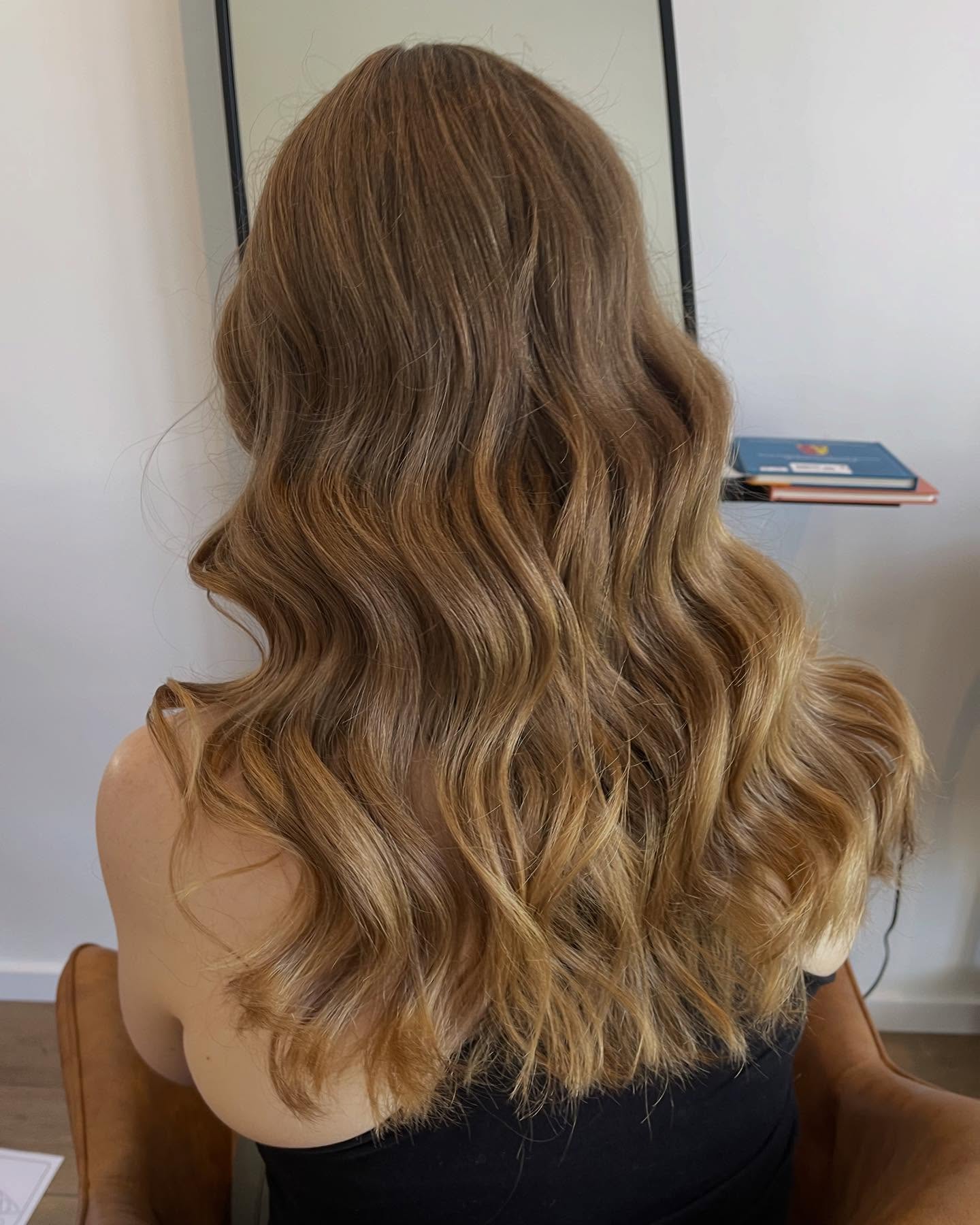 Long warm honey and caramel blonde hair extensions in soft waves, styled by Platinum Hair Extensions in Adelaide.