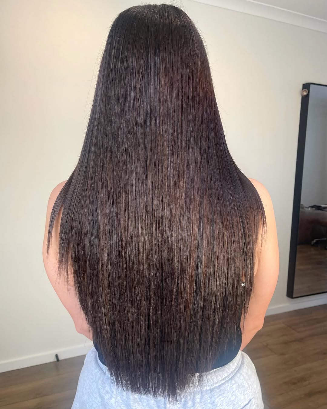 Long brunette weft hair extensions with a sleek blow dry finish